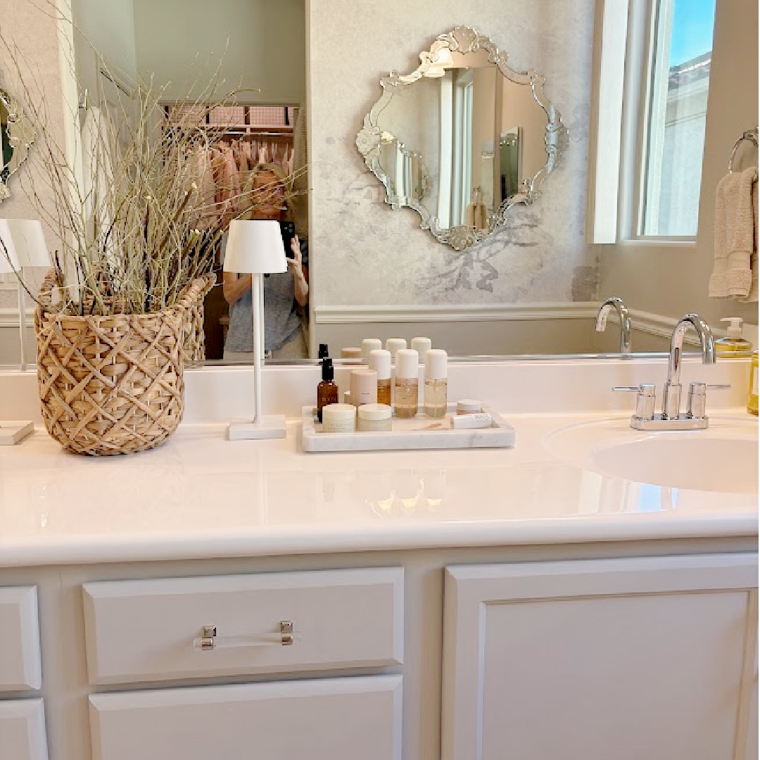 Our renovated bath at the snowbird Arizona house with SW Agreeable Gray painted vanity, lucite hardware, Venetian mirrors layered on a Photowall mural wallpaper, and rugs from Loloi x Amber Lewis - Hello Lovely Studio.