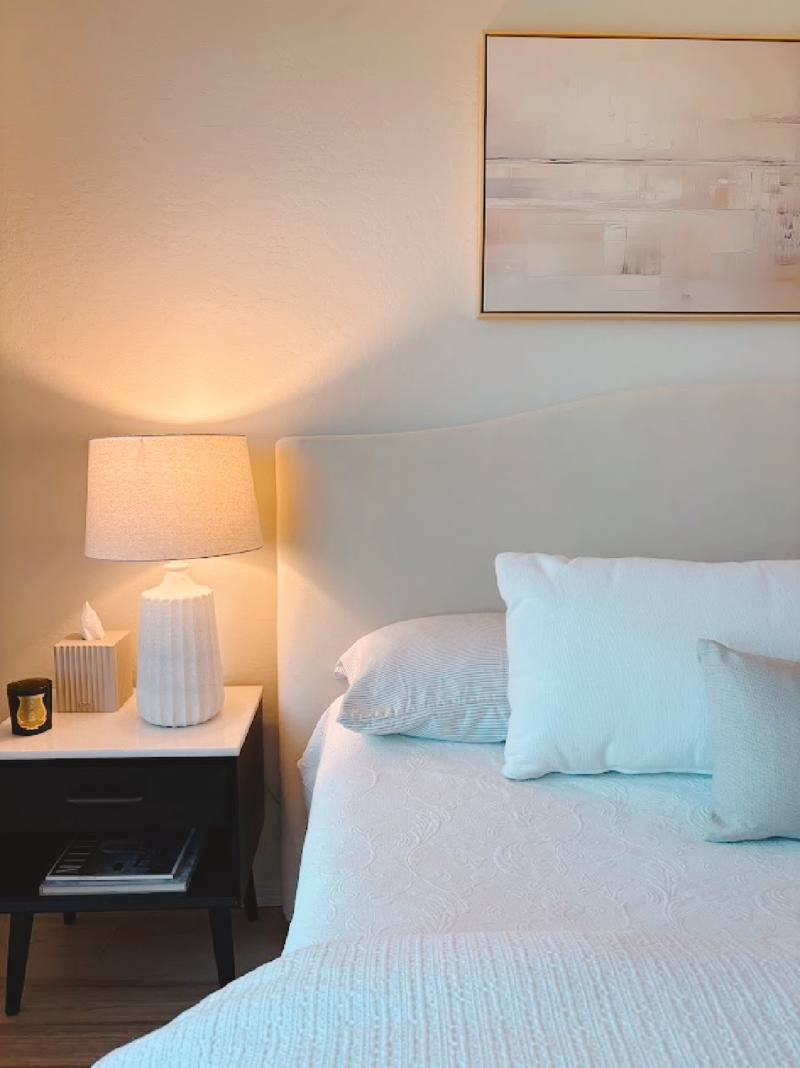 Serene bedroom progress at Hello Lovely's snowbird Arizona retreat. Curved velvet headboard, white linen, black MCM nightstand, and textured lamp.