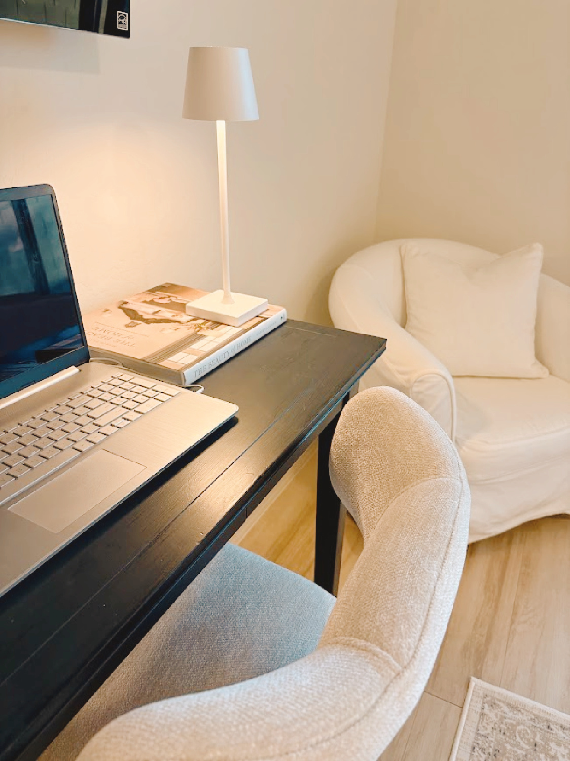 Black console table and modern beige counter stool in Hello Lovely's Arizona bedroom with white barrel chair.