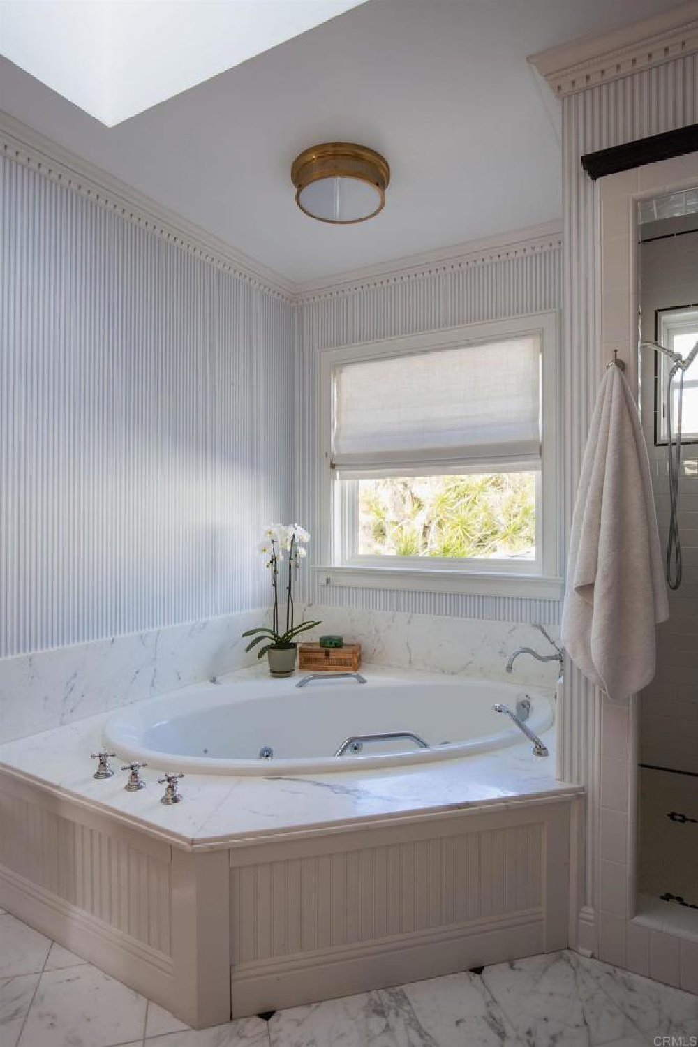 Bath with blue stripe wallpaper at stunning traditional coastal home 5735 Dolphin in La Jolla, CA with interiors by M+M Interior Design. Offered by @nelsonbrothersrealestate
