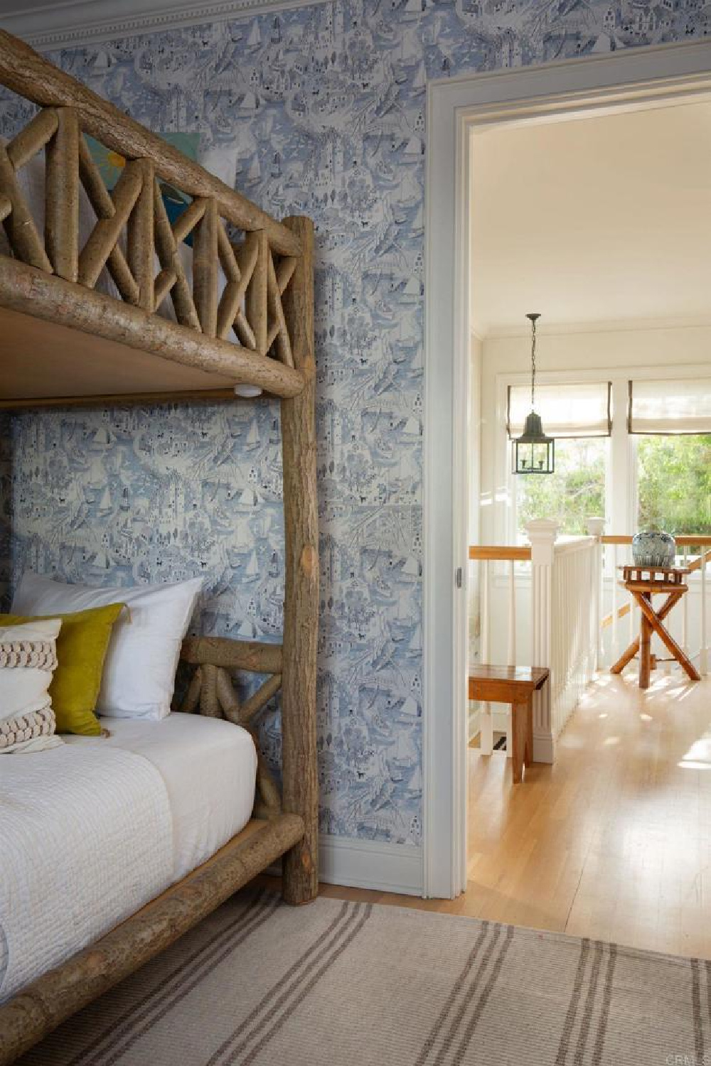 Blue toile wallpaper and rustic log bunks at stunning traditional coastal home 5735 Dolphin in La Jolla, CA with interiors by M+M Interior Design. Offered by @nelsonbrothersrealestate