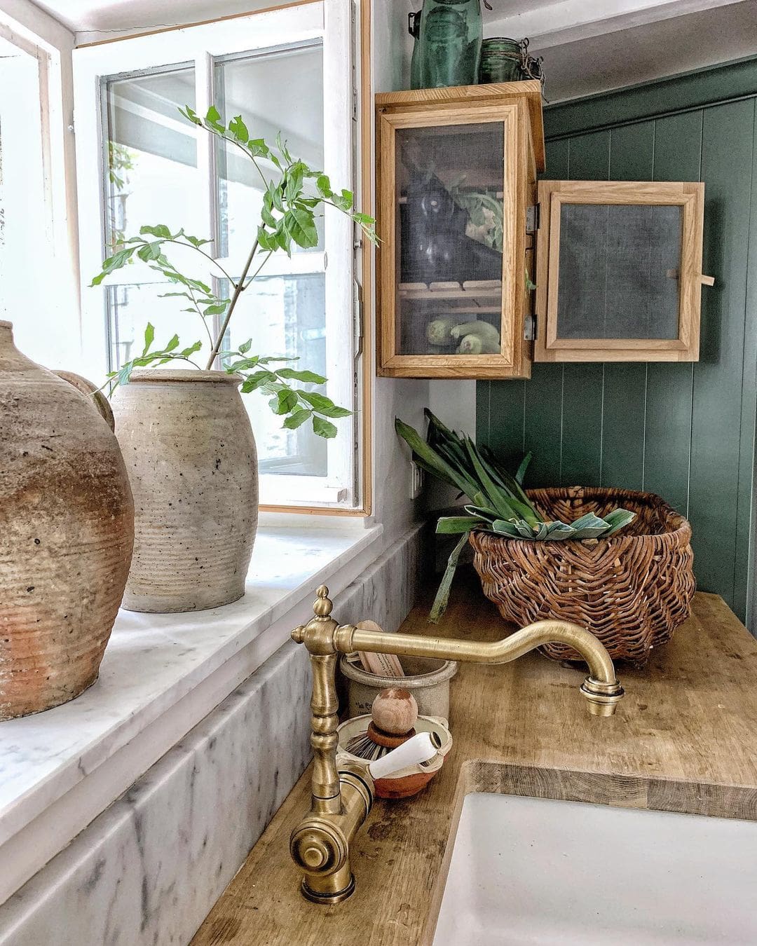 Vivi et Margot's beautiful French country kitchen with green cabinets (F&B Green Smoke) and antique terracotta tile floors.