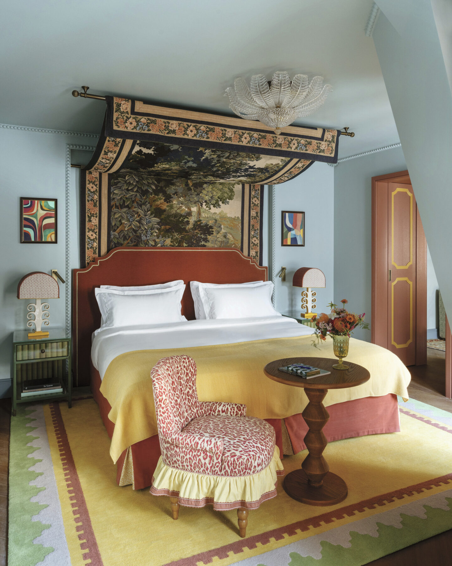 Elegant bedroom design with soft blue walls and tapestry from the book MY LIFE IN COLORS (Rizzoli, 2025) by Martin Brudnizki. Photo by Vincent Leroux.