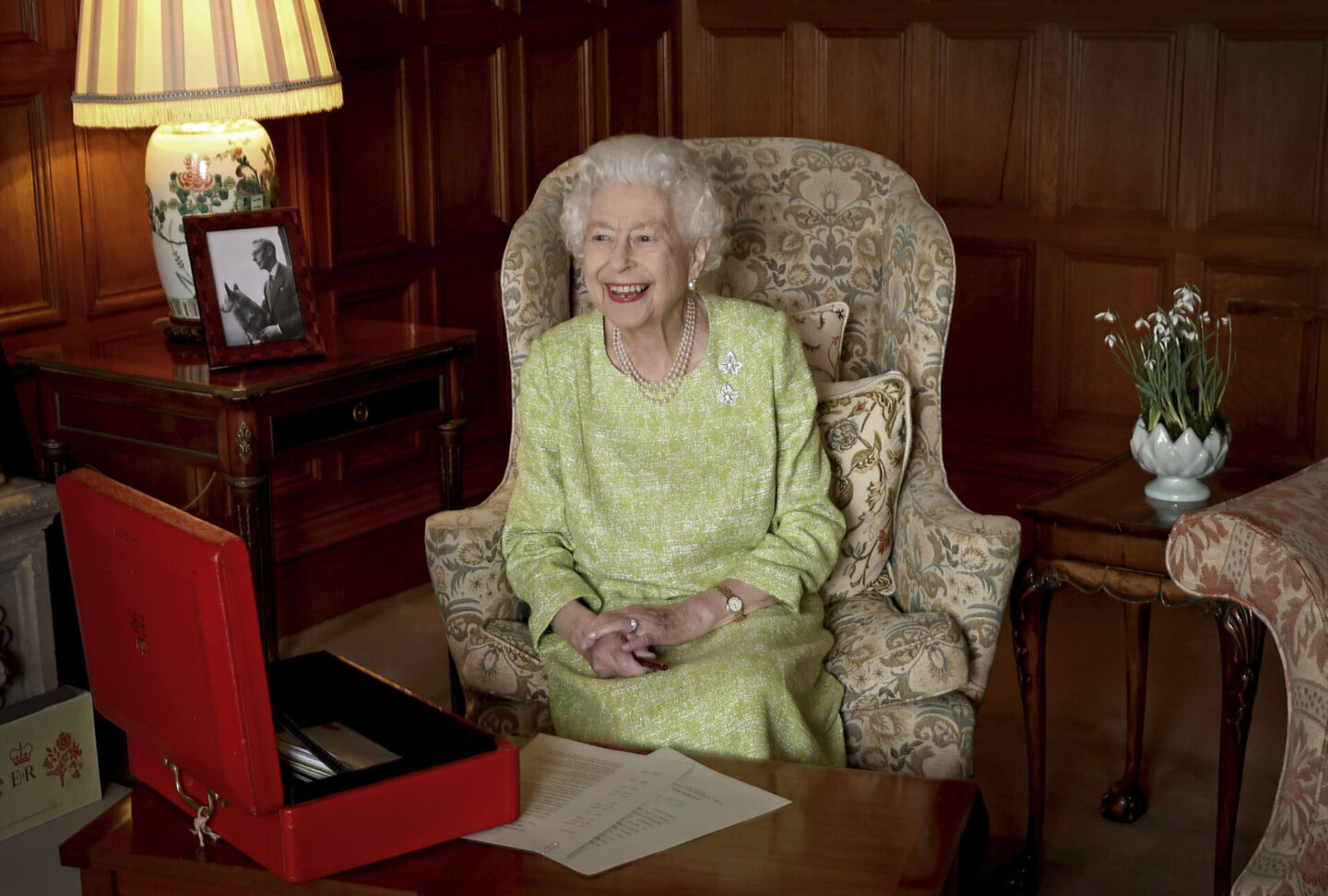 Queen Elizabeth smiling in wing chair - from MODERN MAJESTY (Rizzoli, 2026) by Chris Jackson.