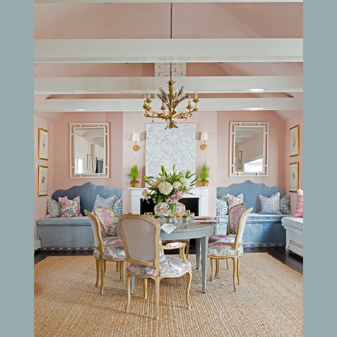 Chinoiserie chic and classic style combine with relaxed elegance in this dining room with pink walls and blue velvet banquettes by Brittany Bromley.