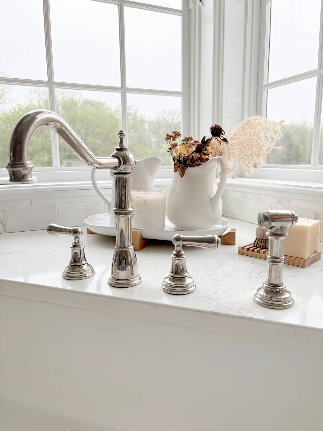 Hello Lovely's modern French kitchen with Muse quartz (Viatera/LX Hausys), Perrin & Rowe faucet, ironstone pitchers, and Living Good Candle Co. Claricomb candle. #livinggoodcandleco