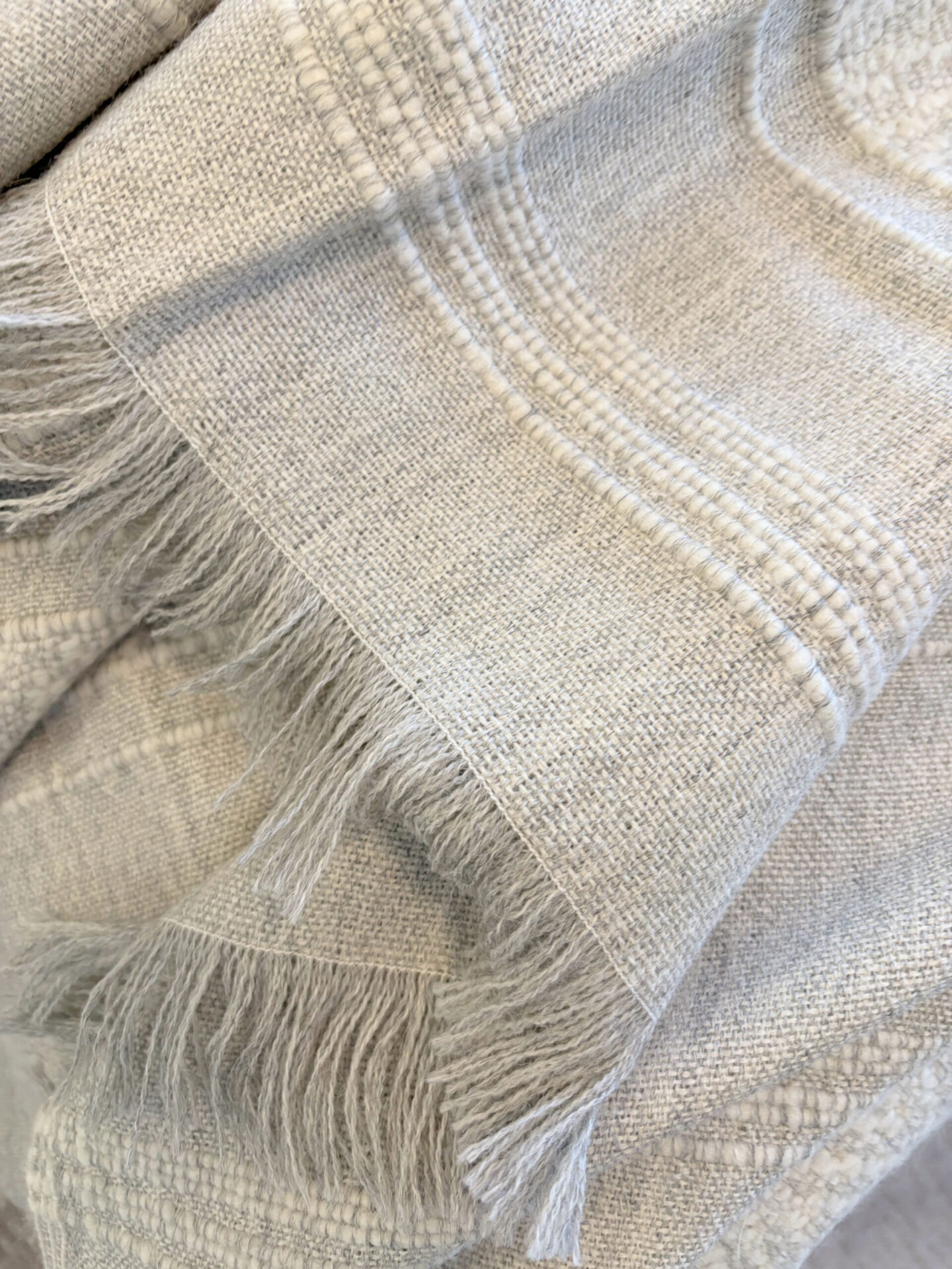 Hello Lovely's superfine alpaca handwoven throw in light grey and white by Purple Nest Design is a timeless natural collectible treasure.
