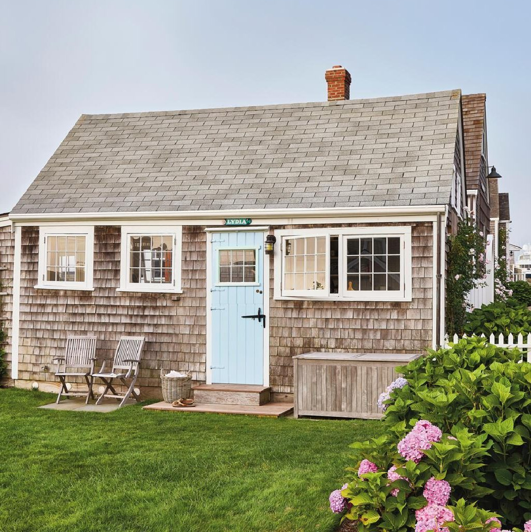 Lydia Cottage coastal cottage exterior with cheerful light blue door in Coastal Living. #coastalhomes 