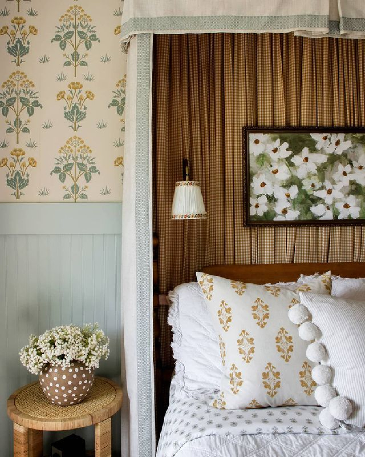 Wildflower Home Interiors designed charming bedroom with canopy, folk art wallpaper, beadboard and layered block printed patterns on bed.
