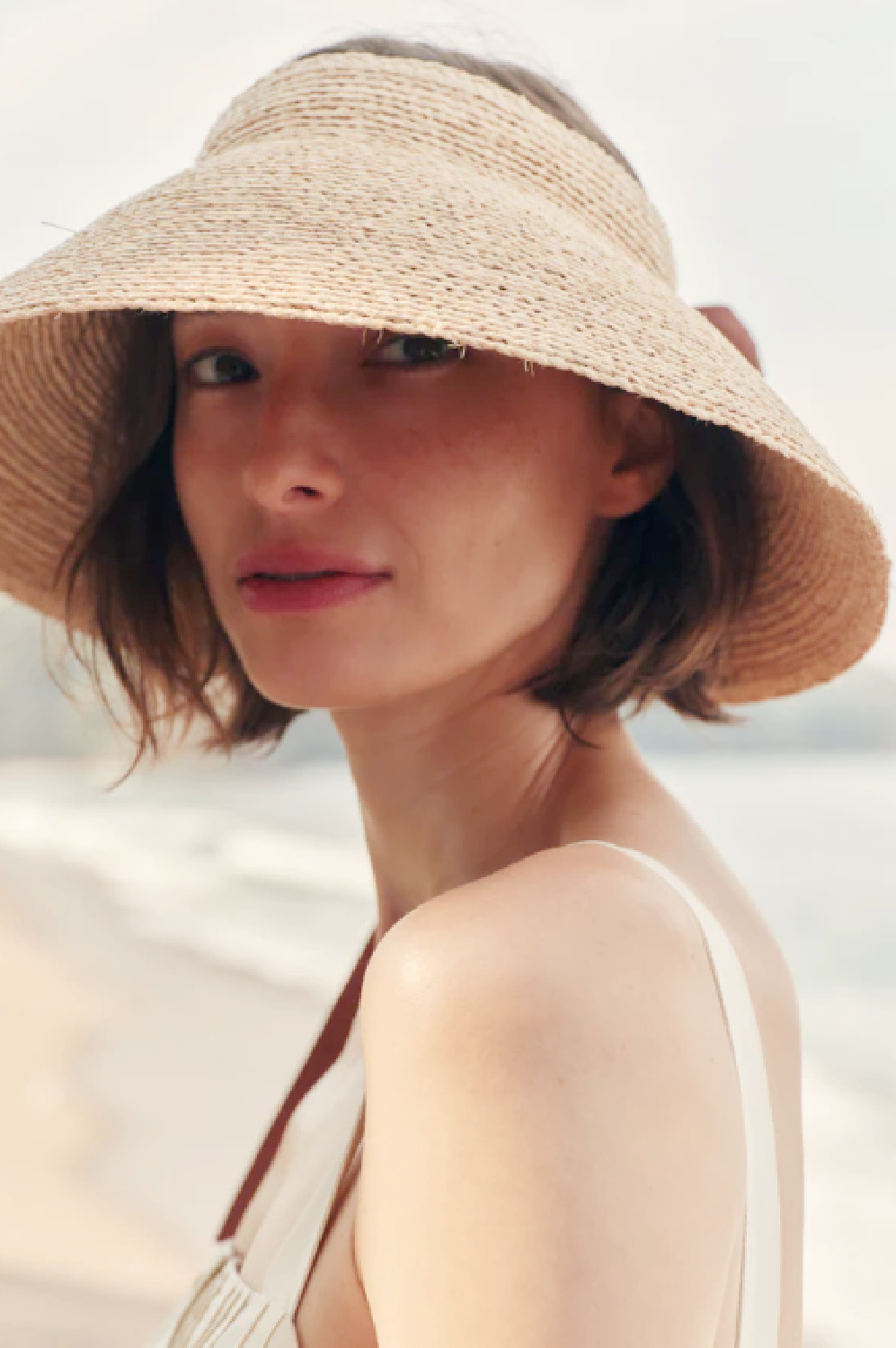 Jenni Kayne Raffia Visor on woman with bob at beach.