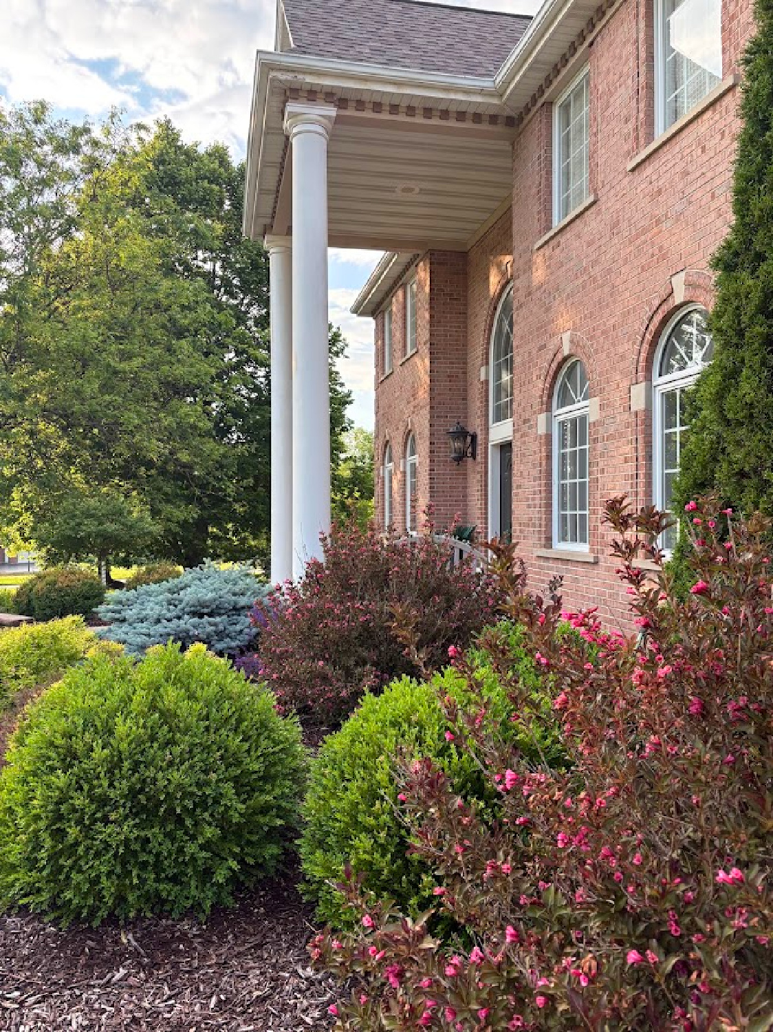 Facade of our brick Georgian with columns in June 2026 - Hello Lovely Studio.
