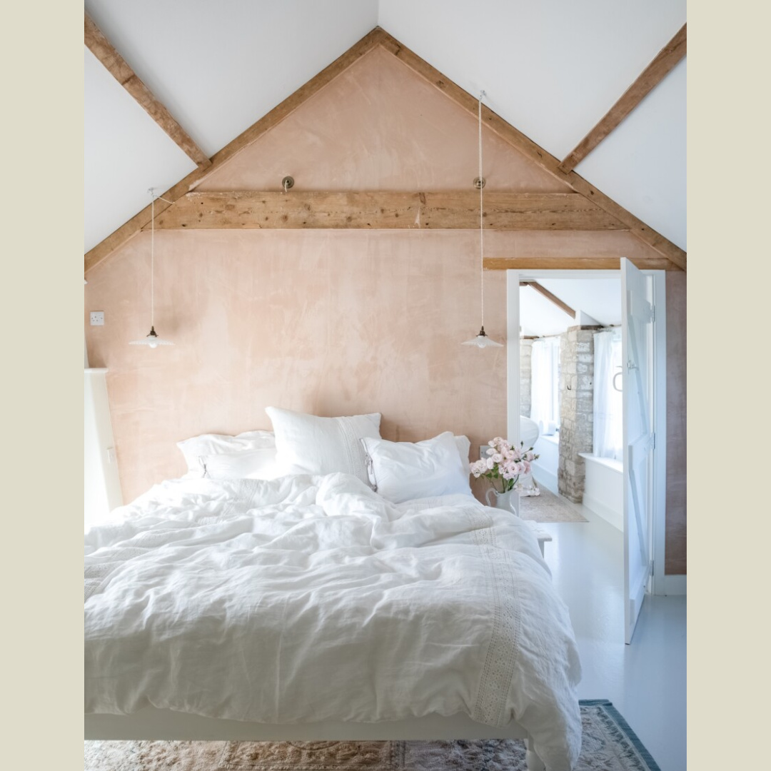 Bedroom with rustic wood beams, Shabby Chic bedding and limewashed walls in Rachel Ashwell's MEADOW MANOR (CICO Books, 2026) in the English countryside; photo by Amy Neunsinger.