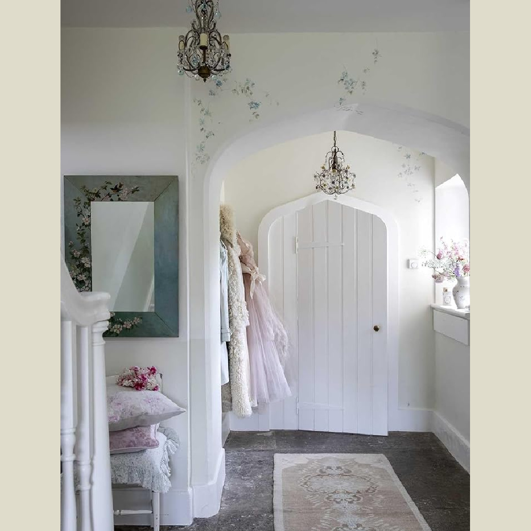 Romantic shabby chic entry with Gothic door and handpainted delicate flowers on plaster walls - from Rachel Ashwell's MEADOW MANOR (CICO Books, 2026). The 17th Century home is in Somerset, England. Photo: Amy Neunsinger.