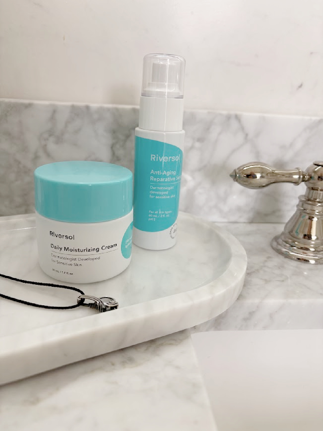 Riversol skincare products on marble tray on Hello Lovely's vanity.