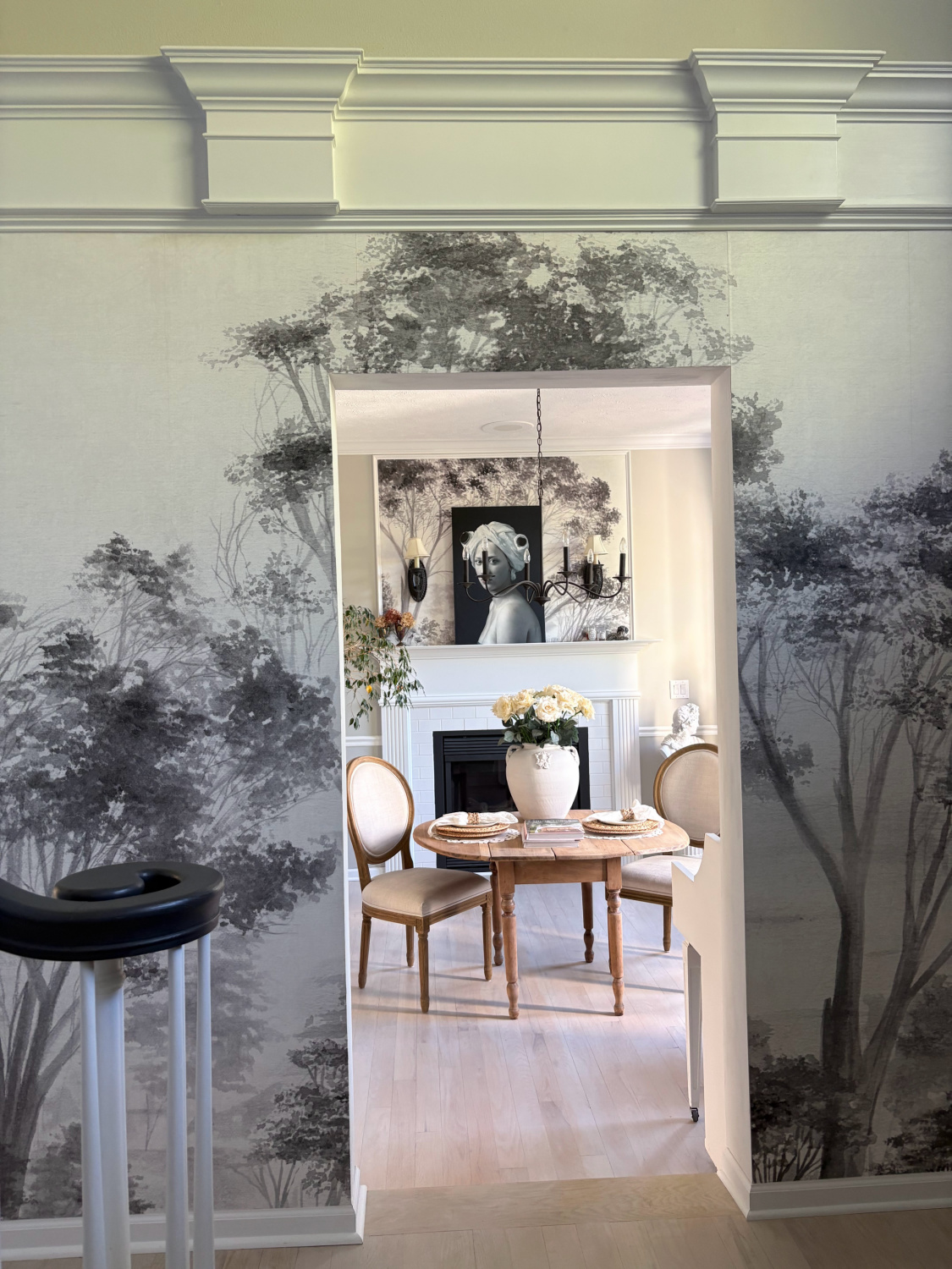 Hello Lovely's dining room at the Georgian. A serene grey landscape mural with trees decorates the entrance and panel above fireplace.