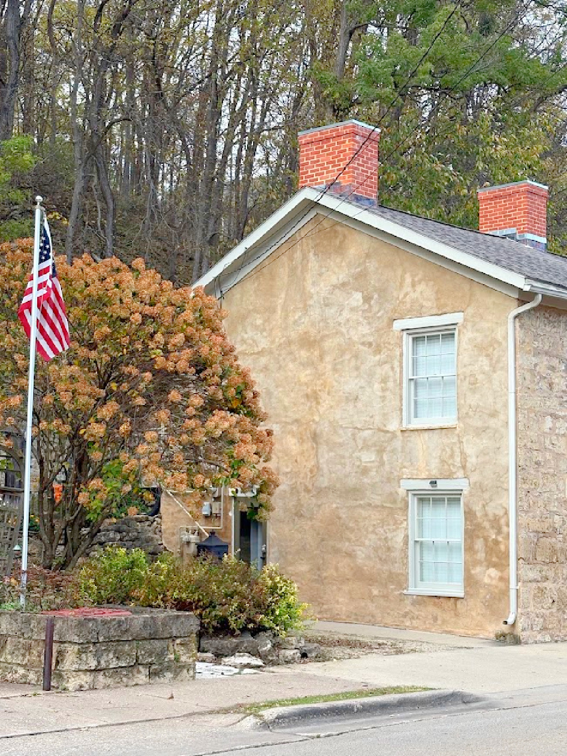 Exterior with fall color. Historic Galena, IL limestone house built in 1827 - Daniel Harrison House (458 Dewey Ave) - photo by Hello Lovely Studio.