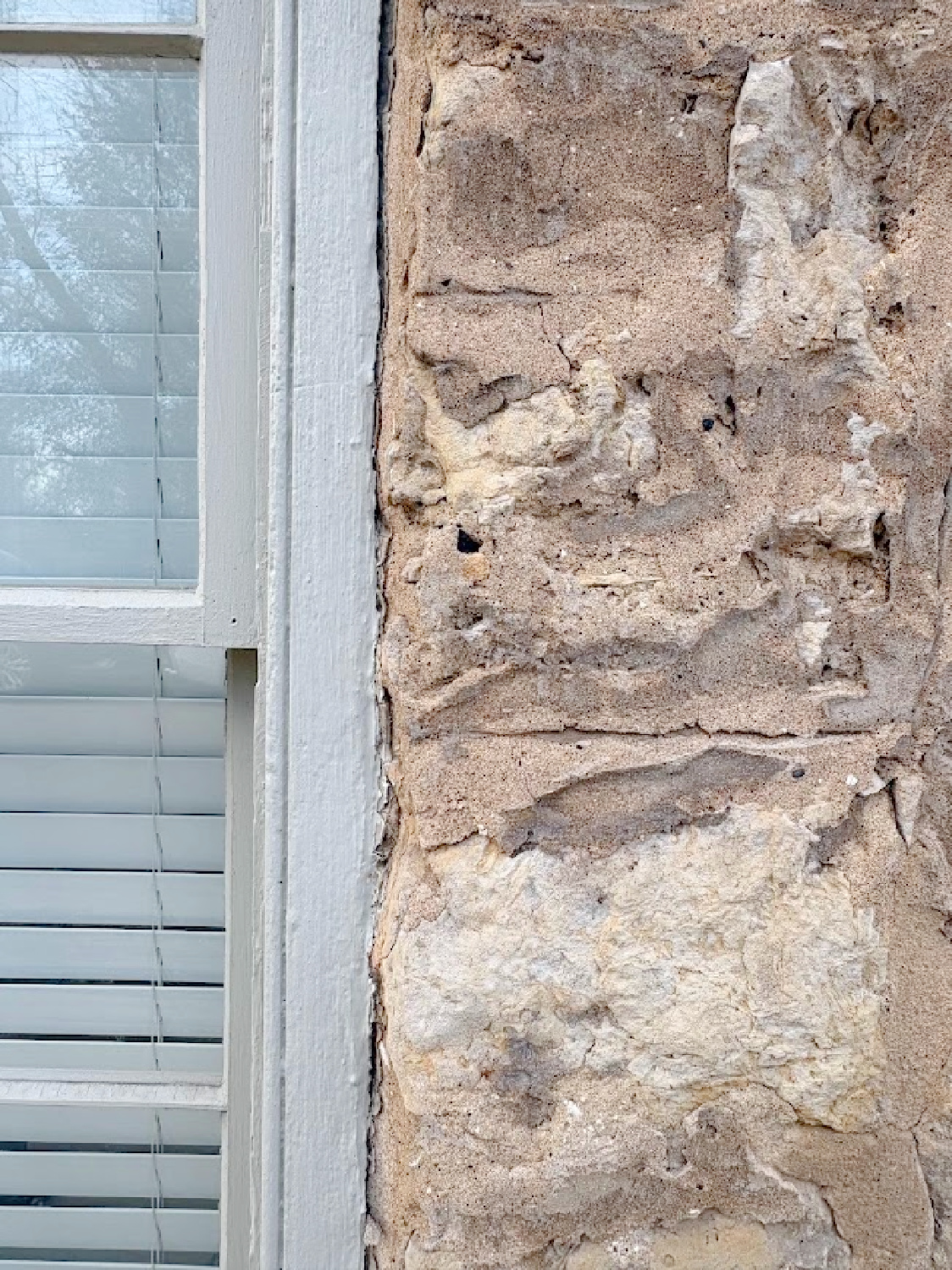 Detail of putty toned painted window trim and limestone. Historic Galena, IL limestone house built in 1827 - Daniel Harrison House (458 Dewey Ave) - photo by Hello Lovely Studio.