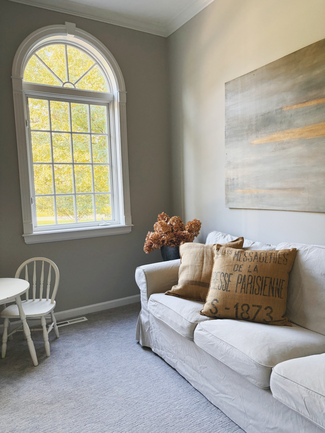 Hello Lovely's living room at the Georgian in fall with original abstract painting by Michele and SW Repose Gray walls.