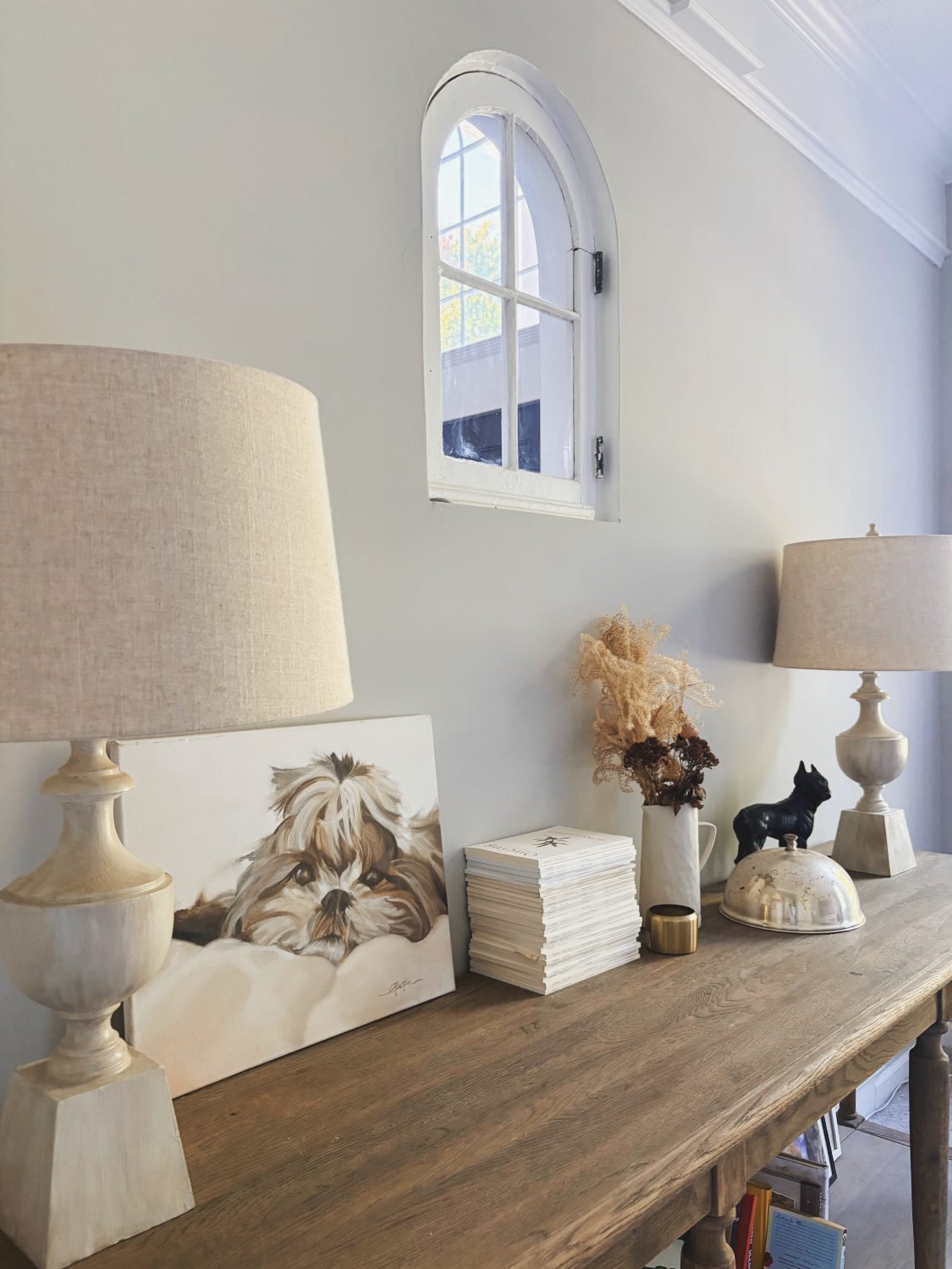 Hello Lovely's living room at the Georgian with RH console table and salvaged arched window from a Tudor cottage.