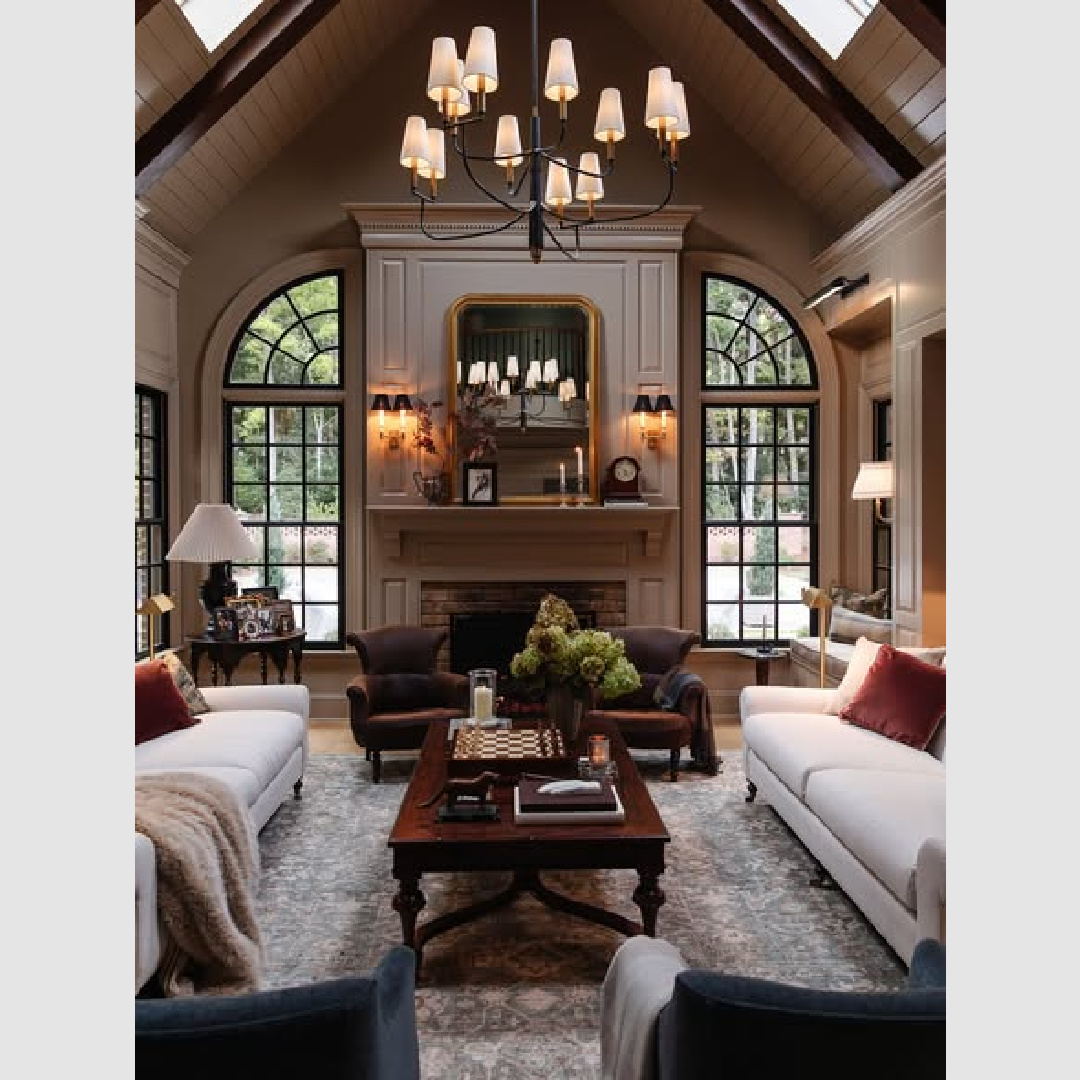 Lovely moody living room with fireplace flanked by decorative windows - ChrisLovesJulia.