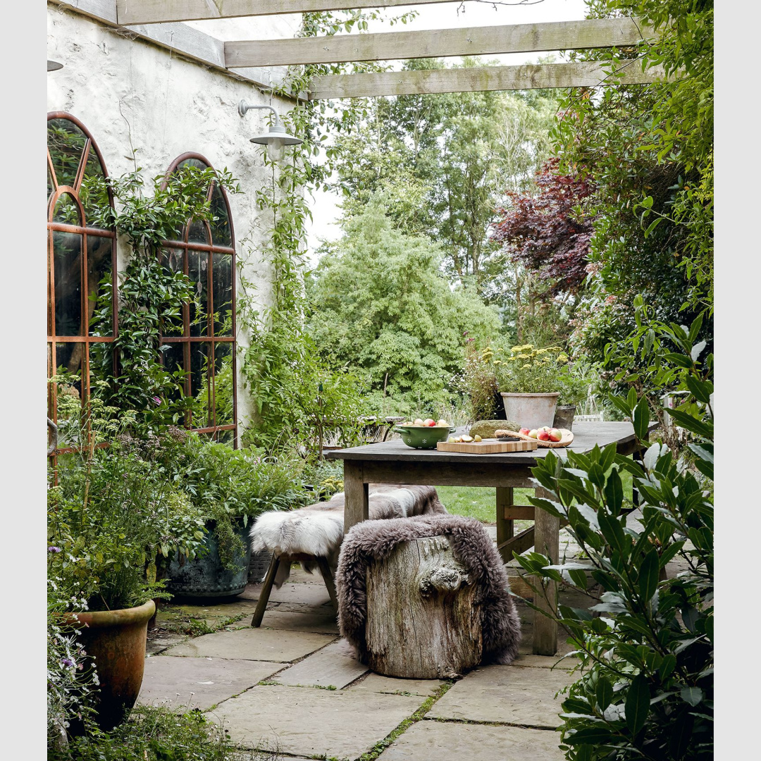 Outdoor dining with sheepskin covered seating - HouseandGardenUk.